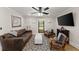 Cozy living room with a leather sofa, patterned rug, and a ceiling fan with lights at 110 Myers Dr, Alpharetta, GA 30009