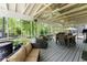 Screened porch with outdoor seating, a heater, and views of the wooded backyard at 110 Myers Dr, Alpharetta, GA 30009