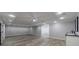 Open basement area with gray vinyl flooring, recessed lighting, and a stylish wet bar at 2667 White Rock Dr, Buford, GA 30519