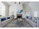 Bright living room with fireplace, high ceiling, neutral walls, ceiling fan, and two sofas with decorative pillows at 2667 White Rock Dr, Buford, GA 30519