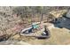 Aerial view of a community playground with a slide, swings, picnic table, and bench surrounded by mature trees at 2667 White Rock Dr, Buford, GA 30519