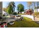 Picture of a grassy backyard featuring an outdoor dining table set, a grill, and tire planters at 302 Cimarron Way, Lawrenceville, GA 30044