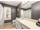 Bathroom featuring a large mirror and vanity with white cabinets and cream-colored countertops at 302 Cimarron Way, Lawrenceville, GA 30044