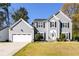 Charming two-story home with a well-maintained lawn and attached two-car garage on a sunny day at 302 Cimarron Way, Lawrenceville, GA 30044
