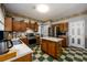 Charming kitchen featuring wood cabinets, stainless steel appliances, an island, and eye-catching checkered flooring at 302 Cimarron Way, Lawrenceville, GA 30044