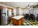 Inviting eat-in kitchen featuring stainless steel appliances, wood cabinets, an island, and checkered flooring at 302 Cimarron Way, Lawrenceville, GA 30044