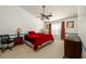 Bright main bedroom featuring a ceiling fan, plush red bedding, neutral carpet and a large window at 302 Cimarron Way, Lawrenceville, GA 30044