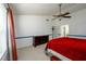Bright main bedroom featuring a ceiling fan, plush red bedding, neutral carpet and a large window at 302 Cimarron Way, Lawrenceville, GA 30044