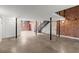 Finished basement with concrete floors, black metal staircase, and brick accent wall at 644 Wells Sw St # 8, Atlanta, GA 30310