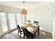 Charming dining room with stylish wallpaper, dark wood table and chairs, and ample natural light at 6980 Roswell Rd # E1, Atlanta, GA 30328