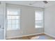 Bedroom with two windows, gray walls, laminate floors, white trim, and light fixtures at 910 Lakeside Ct, Loganville, GA 30052