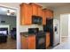 Kitchen featuring wood cabinets, black appliances, and stainless steel refrigerator at 910 Lakeside Ct, Loganville, GA 30052