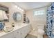 Bright bathroom featuring a white vanity with a marble countertop, decorative mirror, and blue accents at 2850 Gant Quarters Dr, Marietta, GA 30068