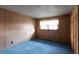 This bedroom features blue carpet and light-colored wood walls and trim at 3856 Egypt Rd, Snellville, GA 30039