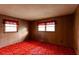 Bedroom with wood paneling, two windows, and colorful carpet; no furniture at 3856 Egypt Rd, Snellville, GA 30039