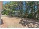 Backyard with side of white home, featuring grass and many trees and bushes at 539 Creekview Overlook, Stockbridge, GA 30281