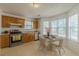 Bright eat-in kitchen features stainless appliances, wood cabinets and a charming breakfast nook at 539 Creekview Overlook, Stockbridge, GA 30281