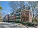 Exterior of brick condominium building featuring balconies, dormer windows, and manicured landscaping at 2921 Lenox Ne Rd # 113, Atlanta, GA 30324