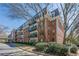 Exterior of The Richmond Condominiums featuring brick facade, balconies, and mature trees at 2921 Lenox Ne Rd # 113, Atlanta, GA 30324