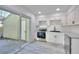 Bright kitchen features stainless steel appliances, white cabinets, and sliding glass door to the backyard at 1124 Country Ct, Lawrenceville, GA 30044
