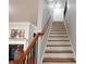 Long staircase with wood handrail, white risers, and black wrought iron balusters leads to main floor at 2620 Sardis Chase Court, Buford, GA 30519