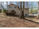 Rear exterior view of home with deck, sliding glass door, and mature trees at 3637 Windmill Rd, Ellenwood, GA 30294