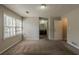 Large primary bedroom with carpet flooring and a view to the attached bathroom at 3637 Windmill Rd, Ellenwood, GA 30294
