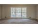 Spacious living room with large windows and carpet flooring, offering lots of natural light at 3637 Windmill Rd, Ellenwood, GA 30294