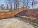Fenced-in backyard with patio and landscaped slope with wooden retaining wall at 5180 Sterling Trace Nw Ct, Lilburn, GA 30047
