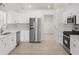Modern kitchen boasts stainless steel appliances, bright white cabinets, and sleek countertops at 5180 Sterling Trace Nw Ct, Lilburn, GA 30047