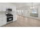 Bright, open kitchen with white cabinets, stainless steel appliances, and adjacent dining area at 5180 Sterling Trace Nw Ct, Lilburn, GA 30047