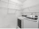 This laundry room with wire shelves, a modern washer and dryer and light floors, has plenty of storage at 5180 Sterling Trace Nw Ct, Lilburn, GA 30047
