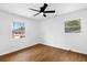 Cozy bedroom features hardwood floors, ceiling fan, and natural light from the windows at 6660 Hidden Brook Trl, Atlanta, GA 30349