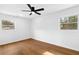 Bright bedroom with hardwood floors, ceiling fan, and natural light from two windows at 6660 Hidden Brook Trl, Atlanta, GA 30349