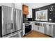 Updated kitchen featuring stainless steel appliances, a black tiled backsplash, and white shaker cabinets at 6660 Hidden Brook Trl, Atlanta, GA 30349