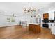 Spacious open-concept living area featuring an updated kitchen, hardwood floors, and modern lighting fixtures at 6660 Hidden Brook Trl, Atlanta, GA 30349