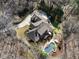 An aerial view of a secluded home with a private pool and backyard oasis surrounded by lush trees at 2160 Bradley Trl, Cumming, GA 30041