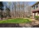 Serene backyard with a lush lawn, mature trees, and a pathway leading to the house at 2160 Bradley Trl, Cumming, GA 30041