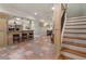 Basement bar with tiled floor, bar seating, wet bar, and adjacent stairs at 2160 Bradley Trl, Cumming, GA 30041