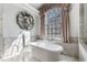 Bathroom features a luxurious stand alone tub next to a large window with decorative trim at 2160 Bradley Trl, Cumming, GA 30041