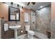 Elegant bathroom featuring a pedestal sink, framed mirror, and a tiled shower with a glass door at 2160 Bradley Trl, Cumming, GA 30041