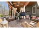 Stylish covered patio with wicker seating, elegant curtains, ceiling fan, and cozy outdoor ambiance at 2160 Bradley Trl, Cumming, GA 30041
