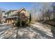 A circular driveway leads to a three-car garage with a stone and siding exterior, nestled in a wooded setting at 2160 Bradley Trl, Cumming, GA 30041