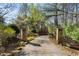 Long private driveway lined with stone pillars and lush landscaping leading to the home at 2160 Bradley Trl, Cumming, GA 30041
