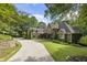 Impressive home with stone and siding, long driveway, and beautifully landscaped front yard with mature trees at 2160 Bradley Trl, Cumming, GA 30041