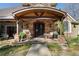 Charming stone home entrance featuring a covered porch with elegant double doors and rocking chairs at 2160 Bradley Trl, Cumming, GA 30041