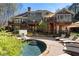 A luxurious pool area with stone decking, lounge chairs, and a multilevel deck overlooking the serene backyard at 2160 Bradley Trl, Cumming, GA 30041