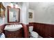 Charming powder room with decorative vanity, elegant mirror, and traditional wainscoting at 2160 Bradley Trl, Cumming, GA 30041
