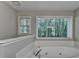 Bright bathroom features a relaxing jacuzzi tub with a view of the private, wooded backyard at 3253 Brookshire Way, Duluth, GA 30096