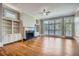 Bright living room featuring hardwood floors, a ceiling fan, fireplace, built-in shelves, and large windows at 489 Carter Se Ave, Atlanta, GA 30317